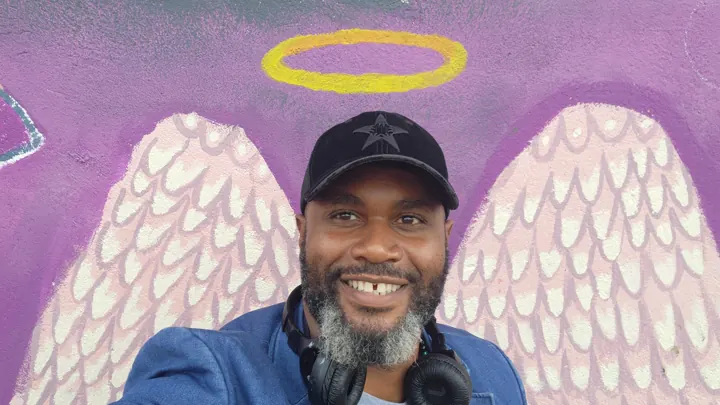 Levi Howze in front of an angel-wings mural