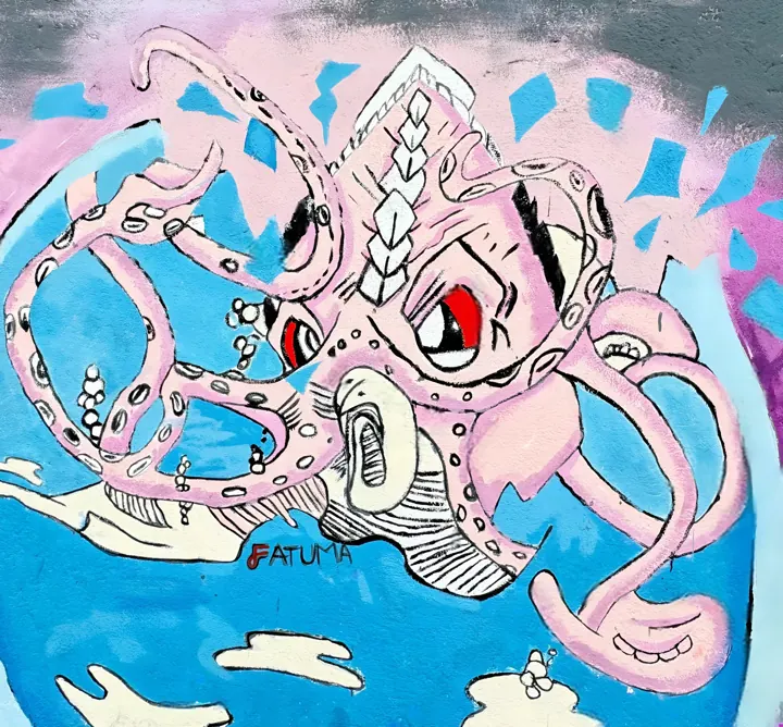 Mural of a large pink octopus against blue sky and clouds, signed FATUMA