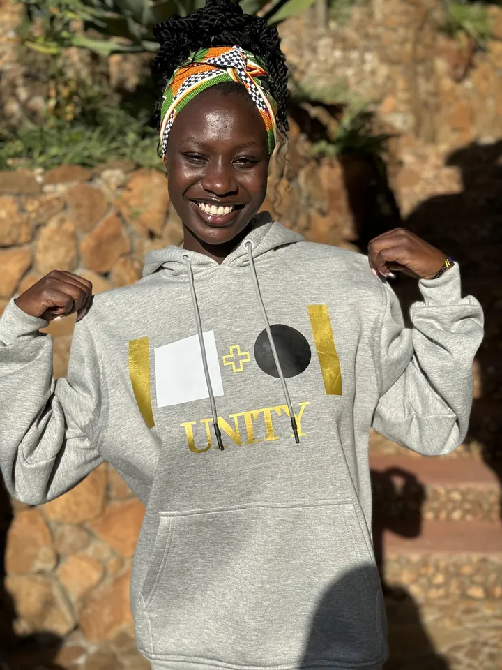 Model wearing the grey Unity hoodie with gold UNITY print